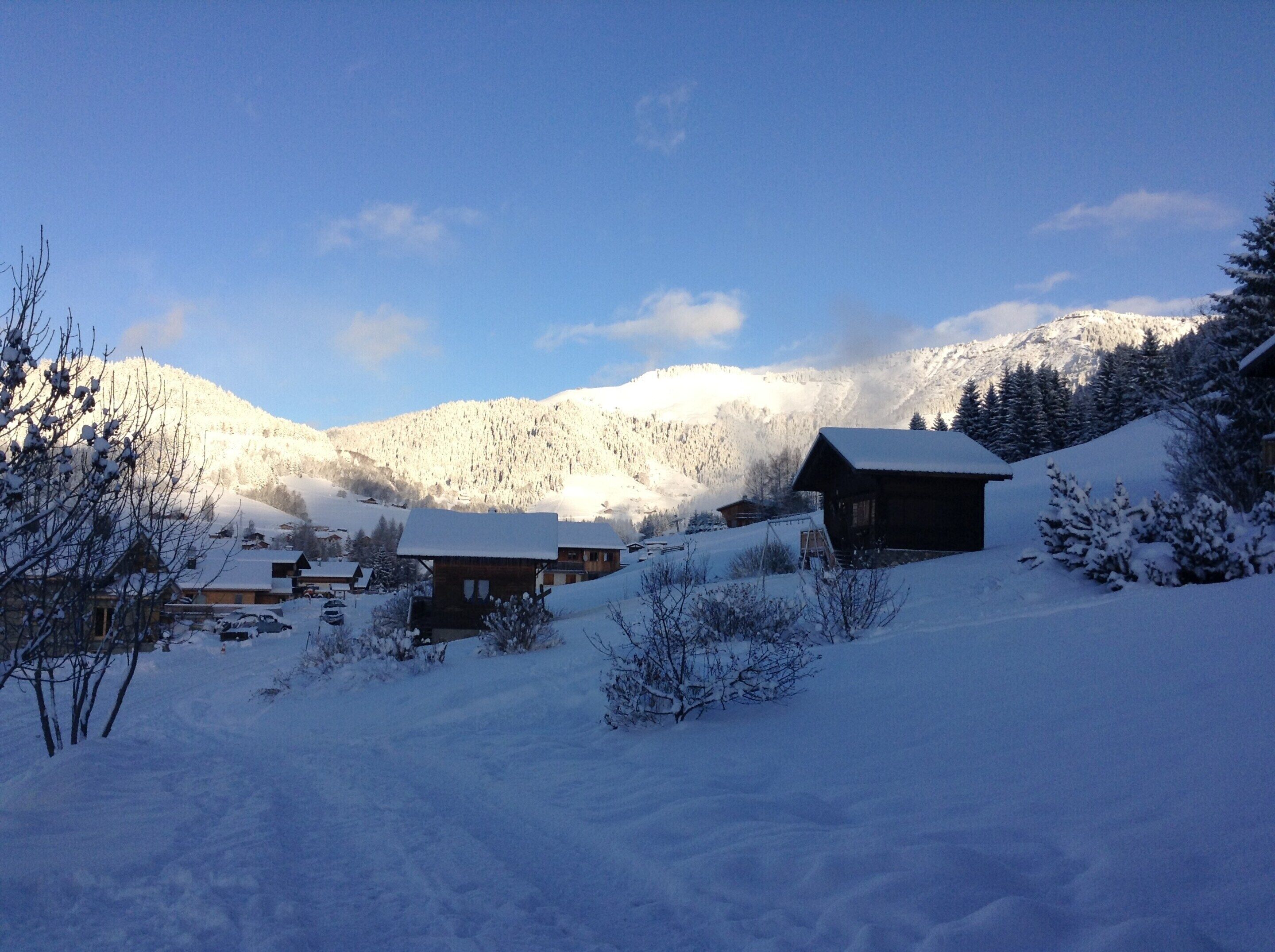 A snow-covered mountain landscape with wooden cabins.