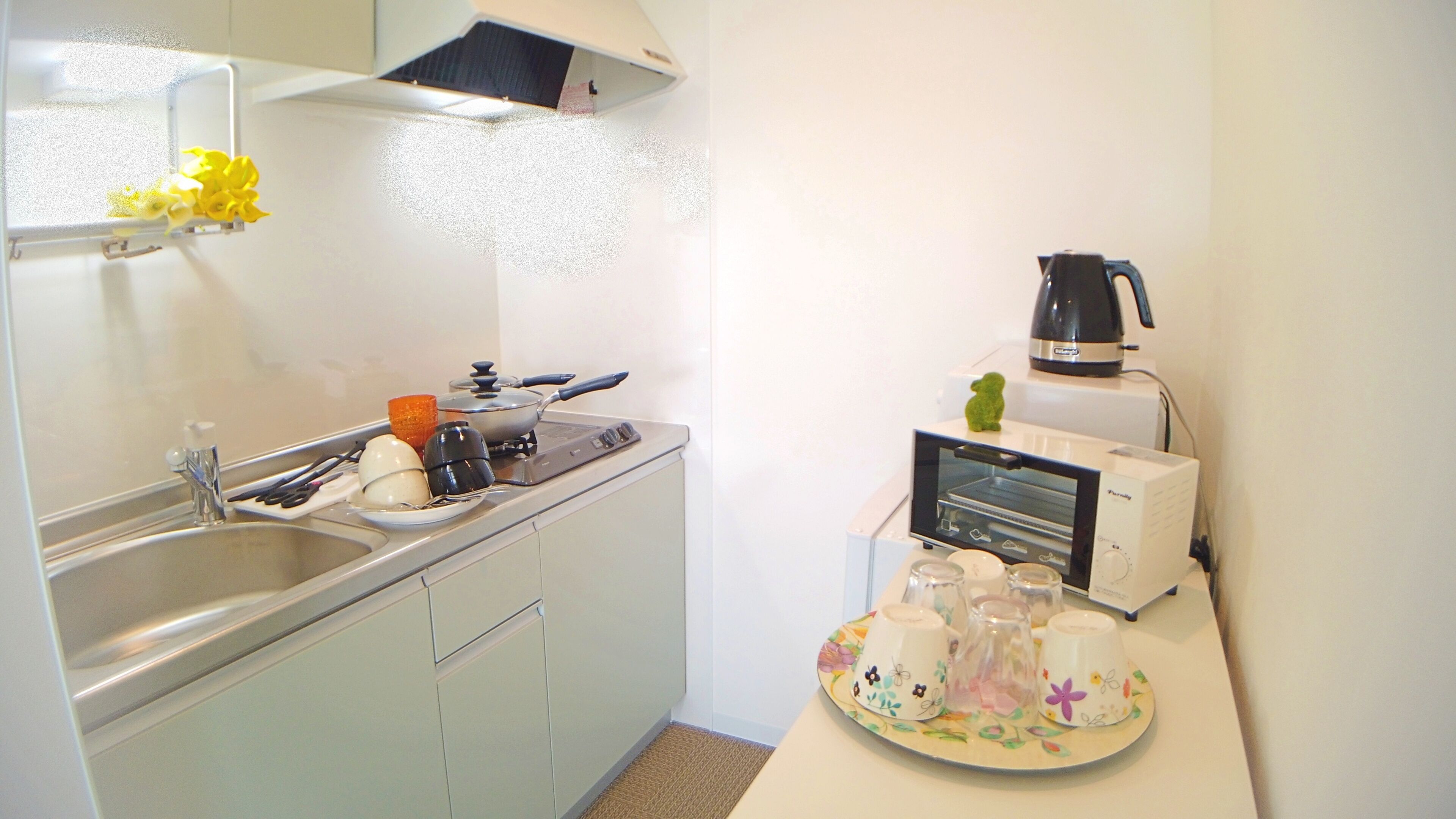 A compact kitchen with a sink, stove, and a toaster oven.