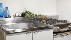 Una cocina de acero inoxidable con un lavamanos doble, estufa y armarios.