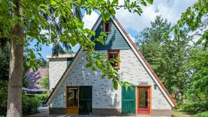 A triangular house with a brick exterior, green doors, and a small porch area. - Villa Near Breda & Biesbosch National Park (Oosterhout)