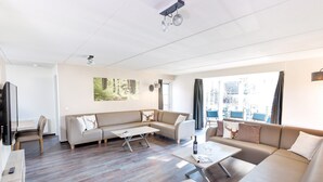 A modern living room with a sofa set, a coffee table, and a TV. - Villa Near Breda & Biesbosch National Park (Oosterhout)
