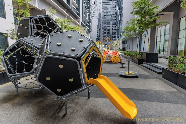 A playground with hexagonal climbing structures and a yellow slide.