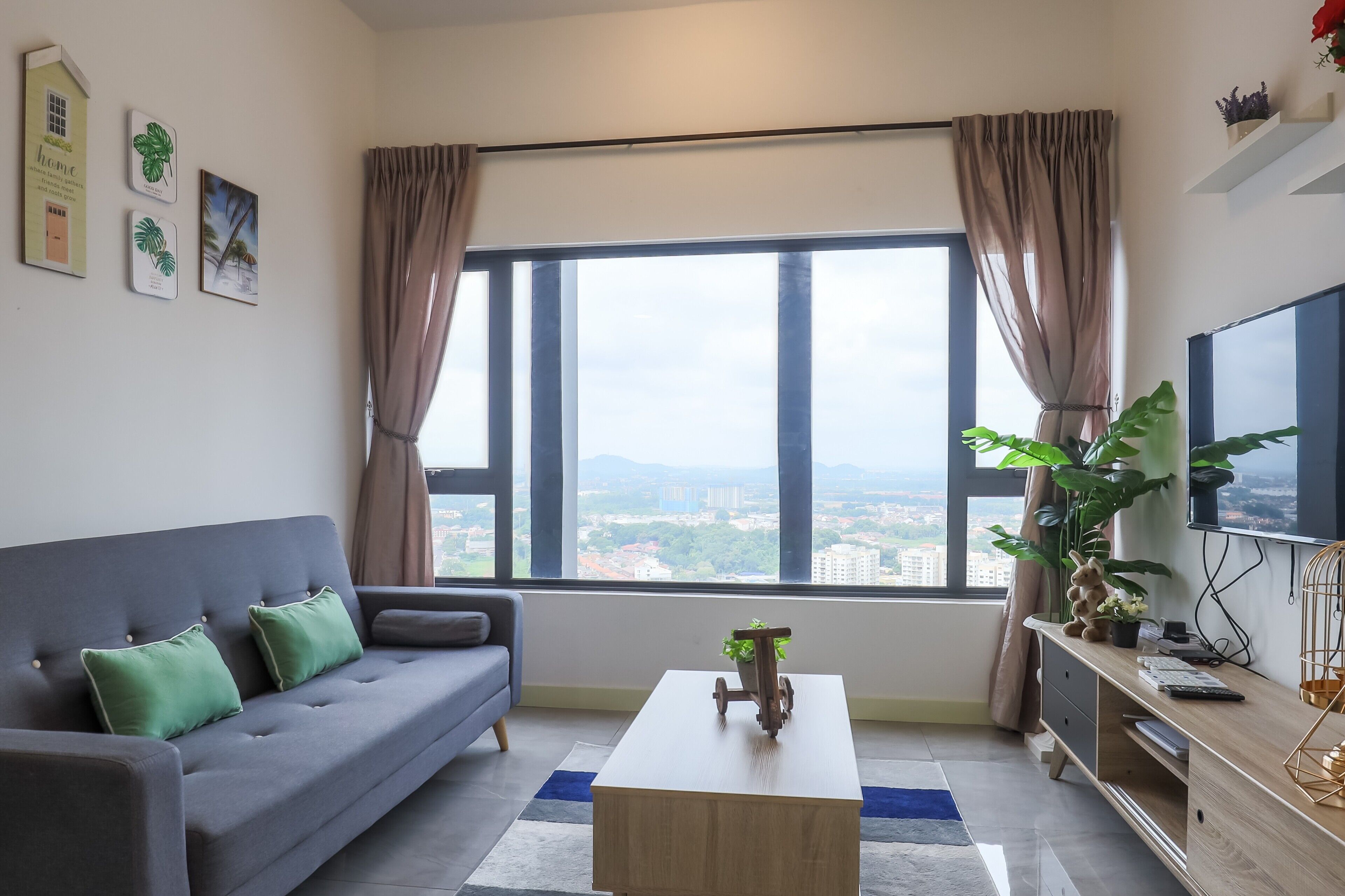 A modern living room with a grey sofa, a coffee table, and a large window with curtains.