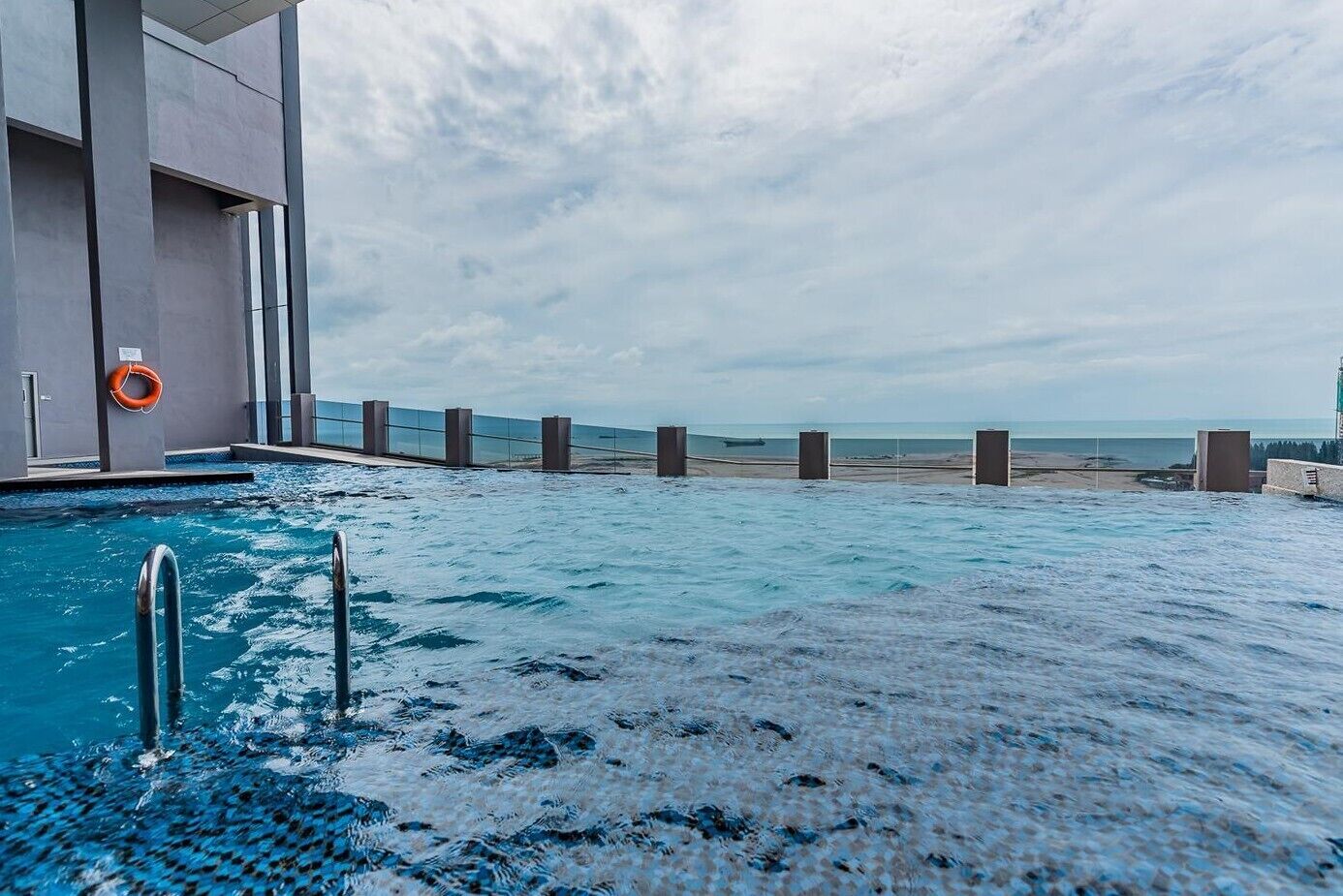 A swimming pool with a view of the beach and ocean.