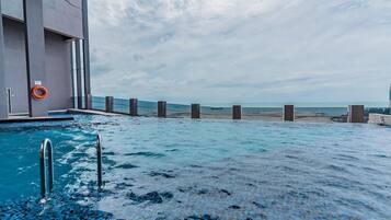 A swimming pool with a view of the beach and ocean.