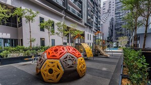 A modern urban playground with a large, colorful play structure, surrounded by residential buildings and greenery. - Imperio Seaview Melaka By I Housing (Malacca City)