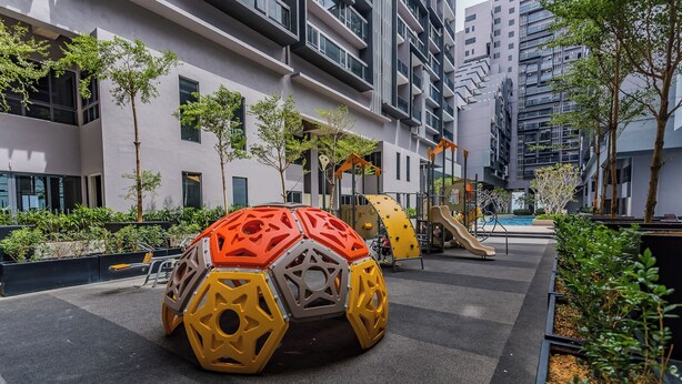 A modern urban playground with a large, colorful play structure, surrounded by residential buildings and greenery. - Imperio Seaview Melaka By I Housing (Malacca City)