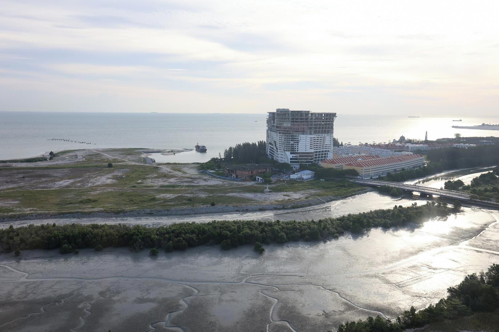 Une zone côtière comprenant un grand bâtiment, une rivière et un pont.