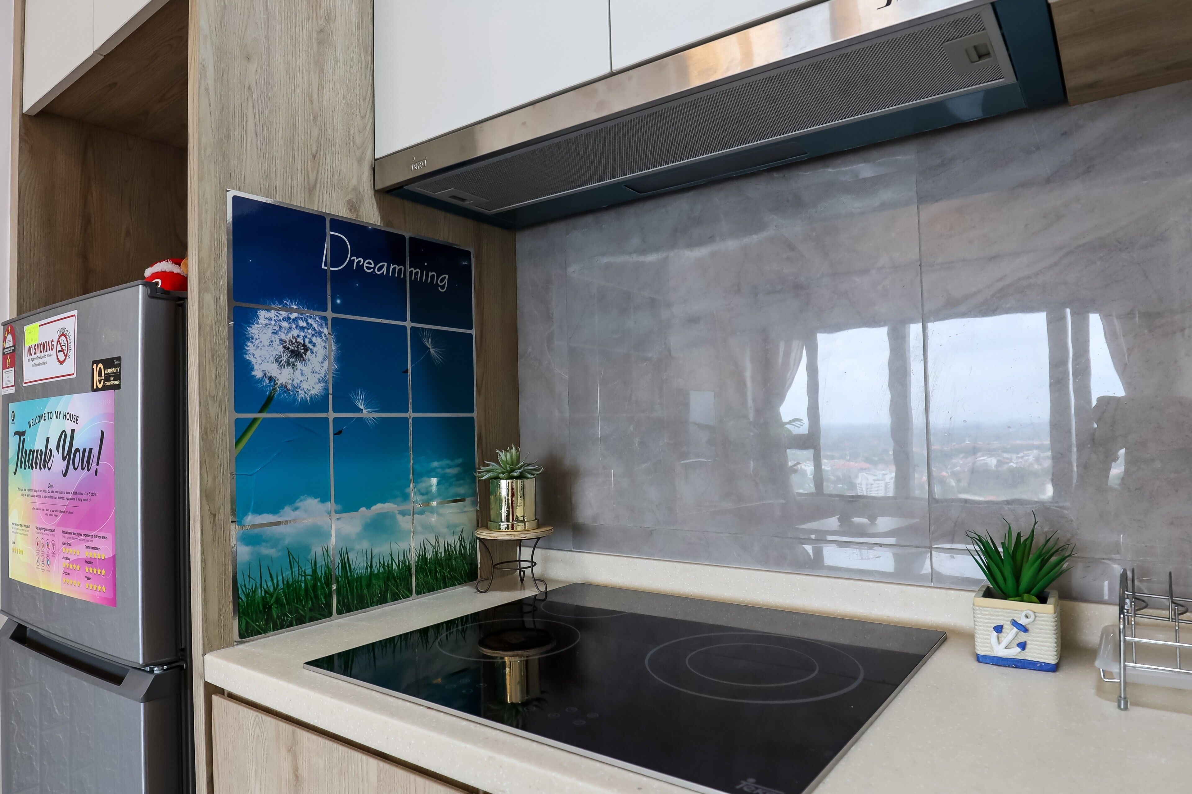 A modern kitchen with a built-in stove, a refrigerator, and a decorative backsplash.