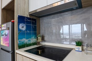 A modern kitchen with a built-in stove, a refrigerator, and a decorative backsplash.