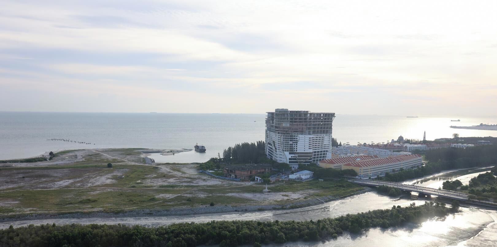 A coastal building with a waterfront view, a bridge, and a river.