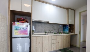 A modern kitchen with a built-in refrigerator, wooden cabinets, and a stainless steel range hood.