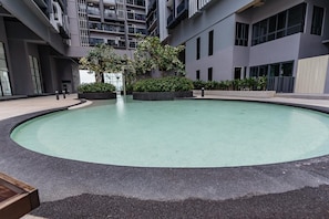 Une piscine intérieure de forme circulaire, entourée d’une promenade et agrémentée de plantes en pot.