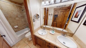 Bathroom features a double sink, bathtub, and shower area.