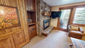 Cozy living room with a fireplace, flat-screen TV, and comfortable sofa.