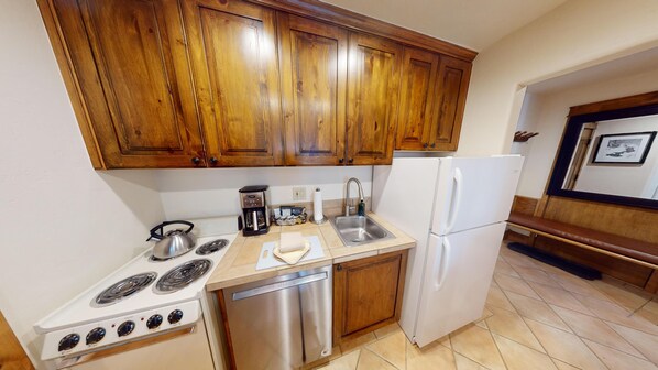 Enjoy cooking in this well-lit kitchen with a stove, sink, and dishwasher, plus a convenient bench for seating.
