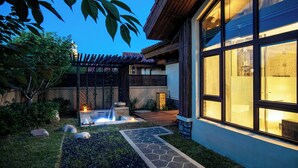 A modern house with a stone pathway leading to a small garden area with a fire feature. - Holiday Inn Dalian Hot Spring by IHG (Dalian)