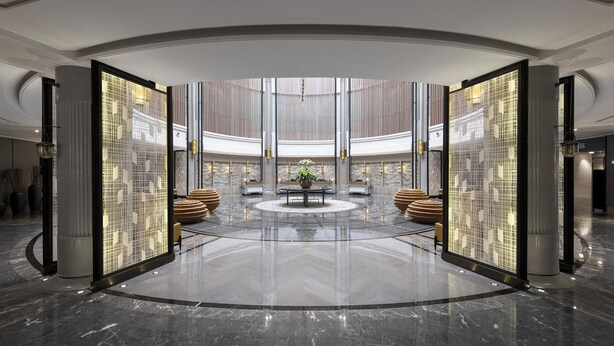 A spacious lobby with a central seating area, a polished marble floor, and a large window providing natural light. - Holiday Inn Dalian Hot Spring by IHG (Dalian)