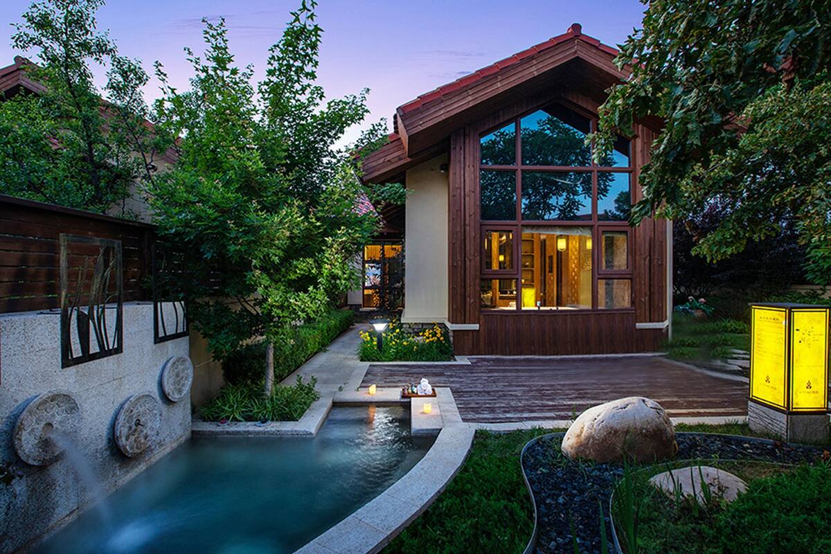 A modern house with a large window, a swimming pool, and a well-maintained garden.