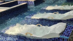 A swimming pool with multiple lanes, each with a starting block and a diving board.