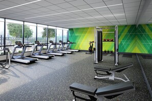 A gym with treadmills, weight benches, and a green wall. - Holiday Inn Fort Worth - Alliance by IHG (Keller)