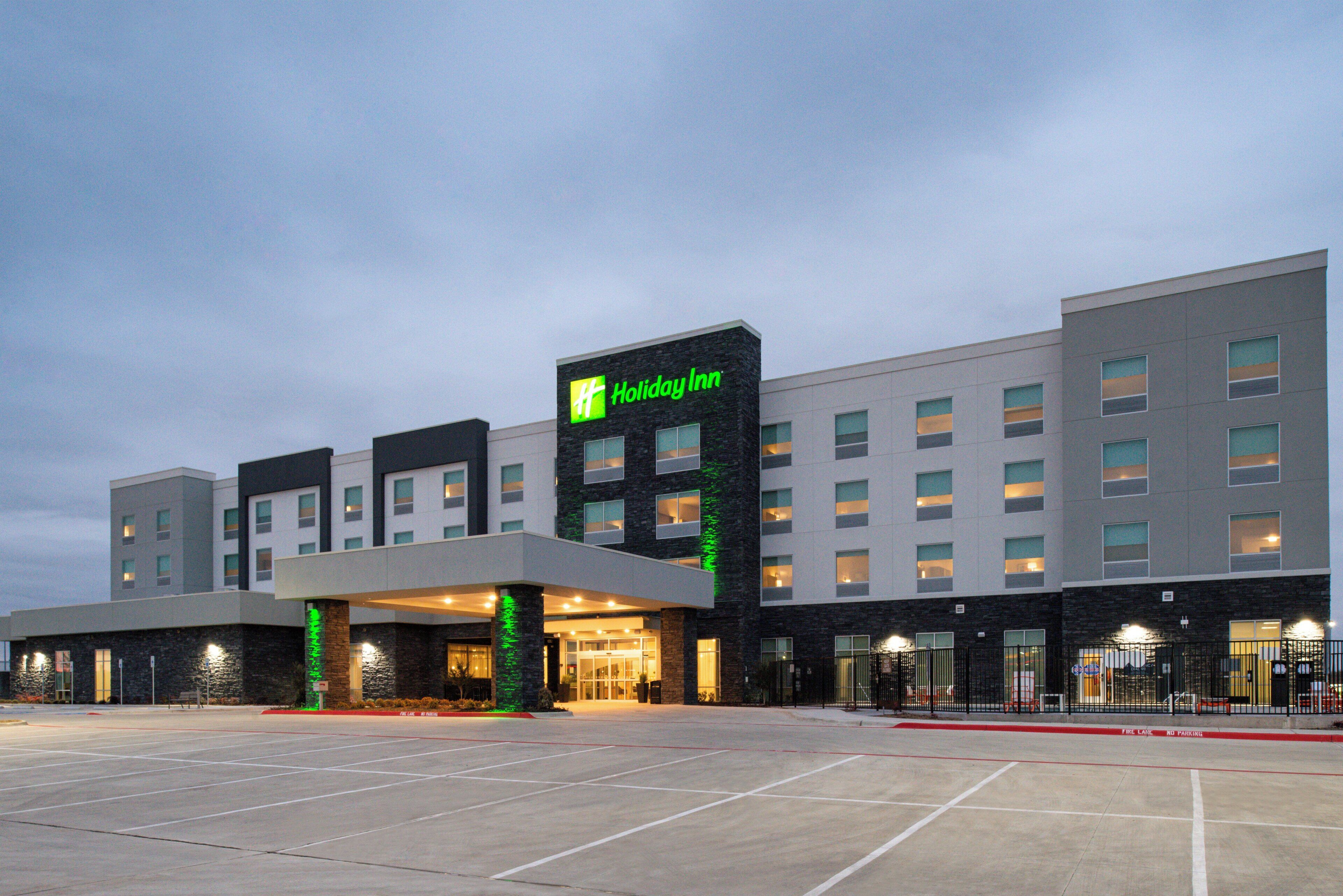 Un hôtel Holiday Inn doté d’une façade moderne, de plusieurs étages et d’un parking situé à l’avant.