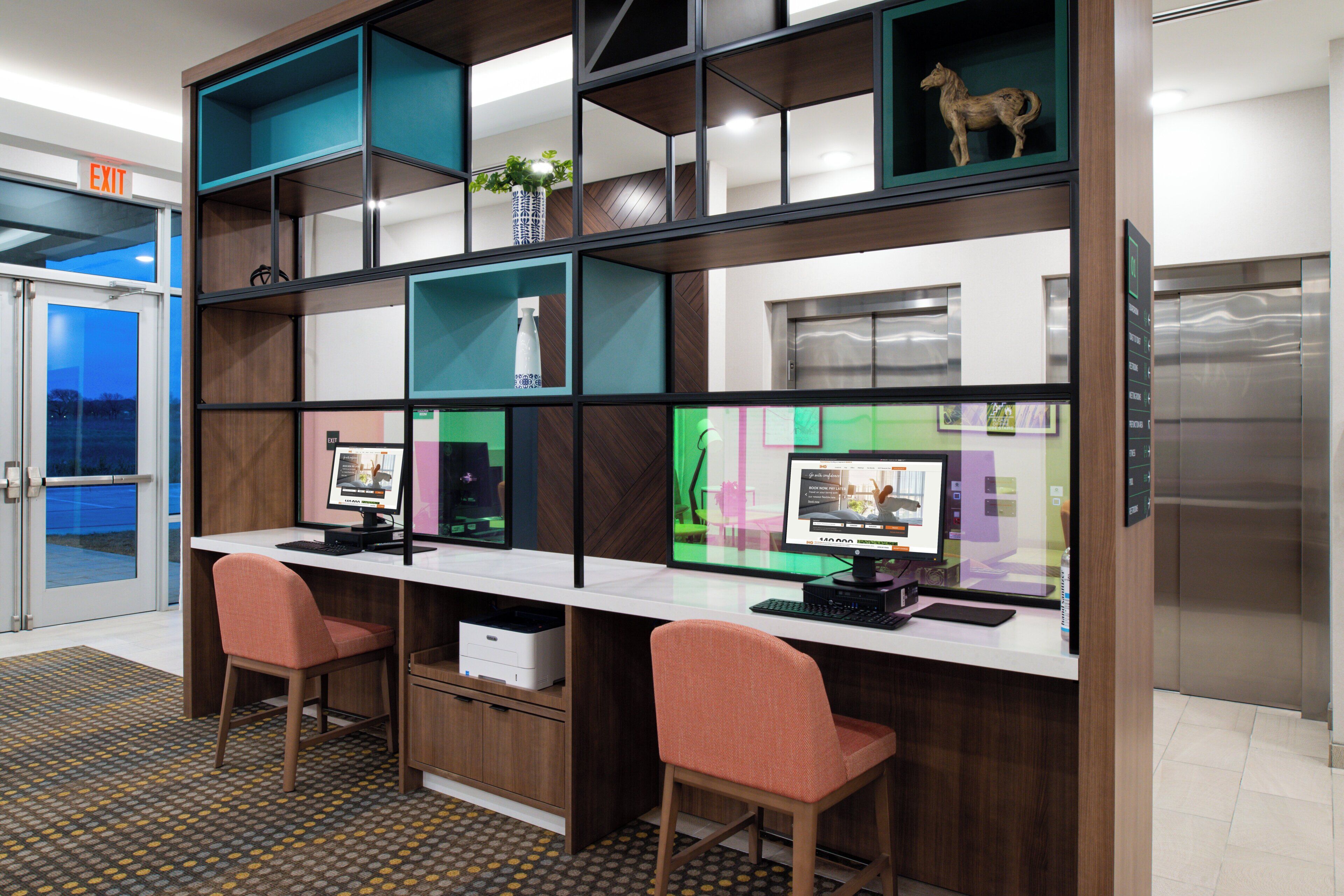 A modern office space with two desks, chairs, and a computer setup.