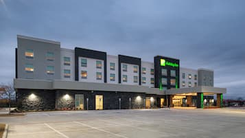 A Holiday Inn hotel with a modern design, featuring a flat roof, multiple windows, and a well-lit entrance.
