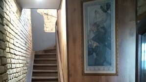 A staircase with wooden steps and a brick wall on one side. - ATRIUM Guesthouse (Riga)
