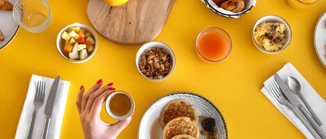 Una mesa de desayuno con diferentes alimentos y una taza de café.
