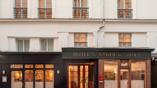 Een hotelgevel in klassieke Europese stijl, met grote ramen en een opvallende ingang.