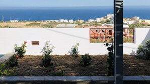 A view of a coastal area with buildings, a clear sky, and a distant view of the sea.