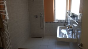 Ein Badezimmer mit Dusche, Waschbecken und Toilette.
