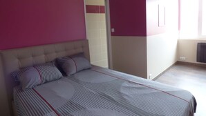A bedroom with a bed, a door, and a window.