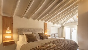 Une chambre à coucher avec un grand lit, une tête de lit en bois, des lampes de chevet et une table de chevet en bois.