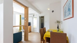 A dining area with a yellow table, brown chairs, and a blue bench.