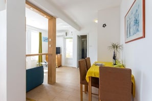 A dining area with a yellow table, brown chairs, and a blue bench. - Charming Studio Apartment With Beautiful Panoramic sea View (Dubrovnik)