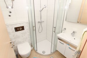 A modern bathroom with a glass-enclosed shower, a toilet, and a sink with a towel hanging on the wall. - New Beach 4 Star Luxury Apartment 3 Bedrooms 3 Bathrooms, Free Boat Berth (Seget)