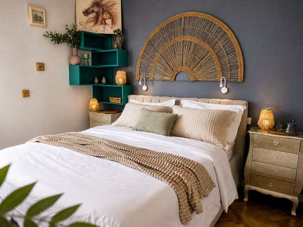 Une chambre à coucher comprenant un lit, une table de chevet, une étagère fixée au mur et une œuvre d’art décorative.