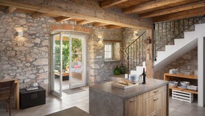 A rustic kitchen with stone walls, wooden beams, and a stone staircase. - Villa Flavia - Stunning Villa in Istria, Croatia (Umag)