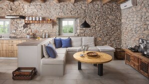 A rustic kitchen with stone walls, wooden beams, a stone countertop, and a wooden dining table. - Villa Flavia - Stunning Villa in Istria, Croatia (Umag)