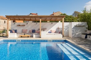 A swimming pool with a wooden pergola and white sofas with striped cushions. - Villa Flavia - Stunning Villa in Istria, Croatia (Umag)