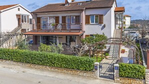 A two-story house with a balcony, a staircase, and a garden. - Spacious and Comfortable Apartment in Medulin, Croatia (Medulin)