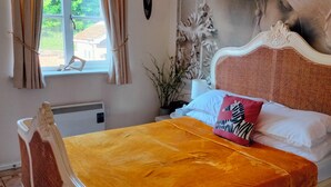 Ein Bett mit gelber Bettdecke, weißem Kopfteil und dekorativen Kissen.