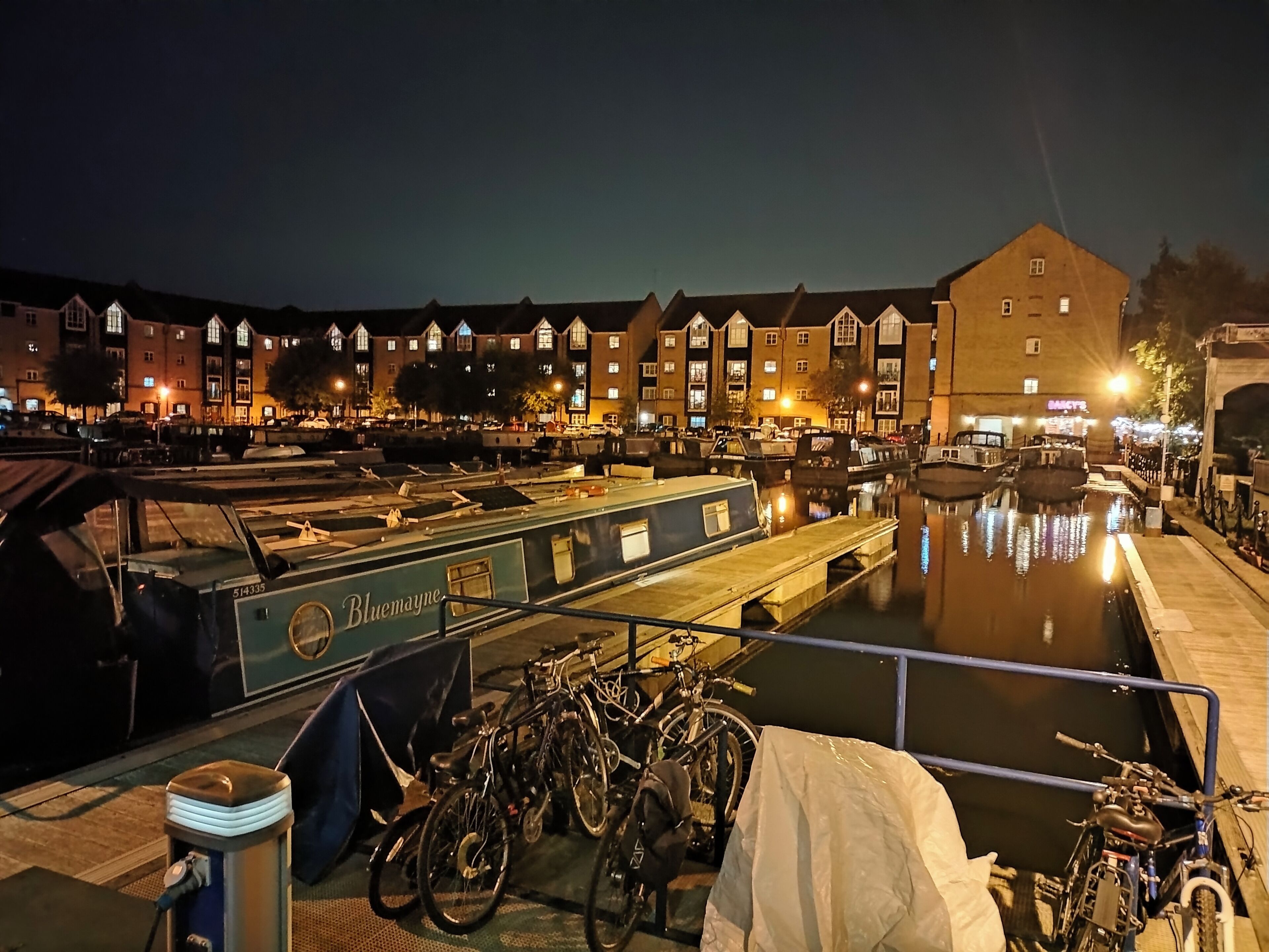 Un edificio a la orilla de un canal con un barco llamado 'Bluemayne'.