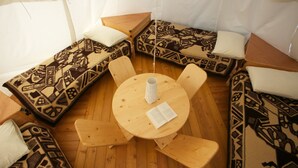 Un rincón acogedor con cojines estampados y una mesa de madera con un libro y una taza.