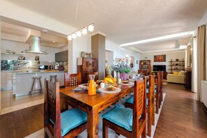 A spacious kitchen with a dining area, wooden furniture, and a modern design.