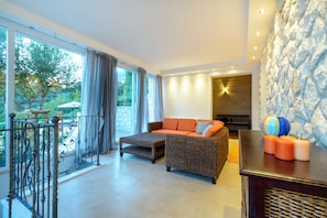 A modern living room with a sofa, ottoman, and a fireplace. - Villa Soline Luxurious Private Seaside Retreat Near Dubrovnik (Zupa dubrovacka)