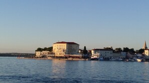 A waterfront building with a casino and lounge bar, boats docked nearby, and a church spire in the background.