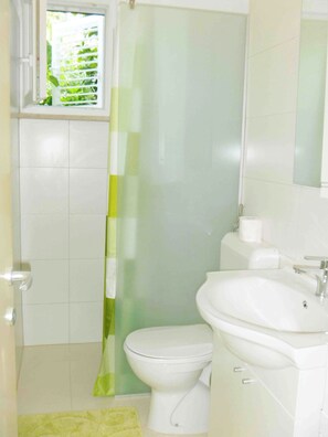 A bathroom with a toilet, sink, and a shower curtain.